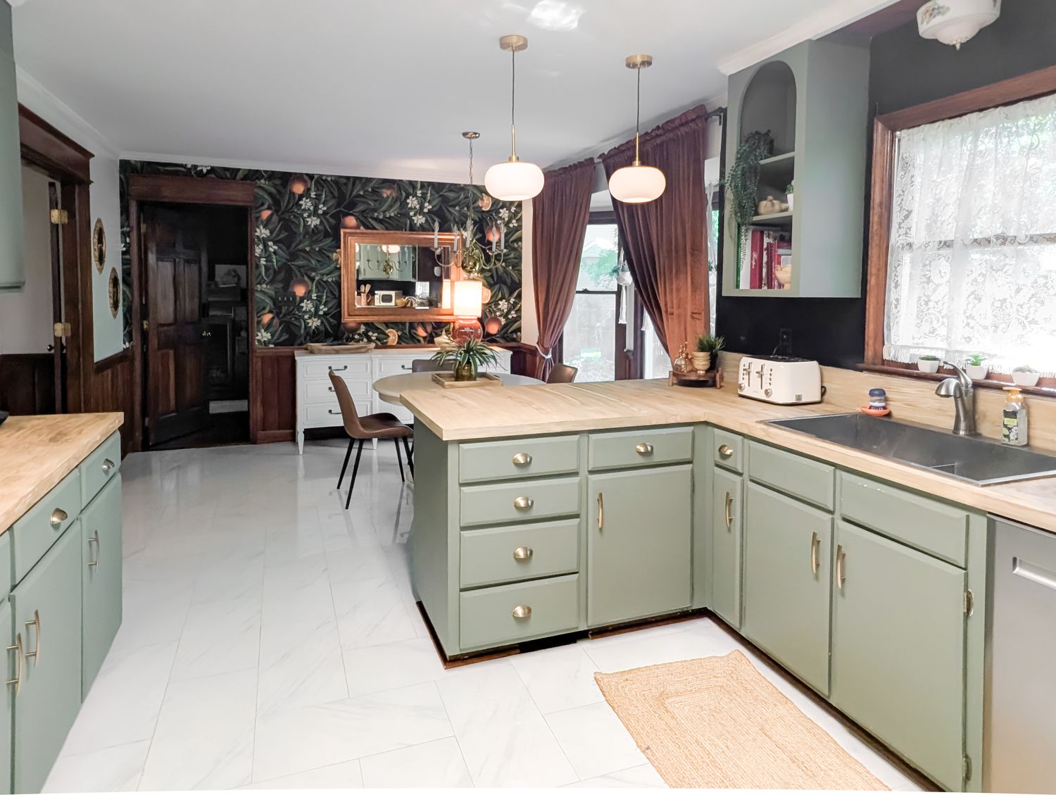 Kitchen with sage-green cabinetry, brass pendant lighting, custom tile flooring and a sunlit breakfast nook